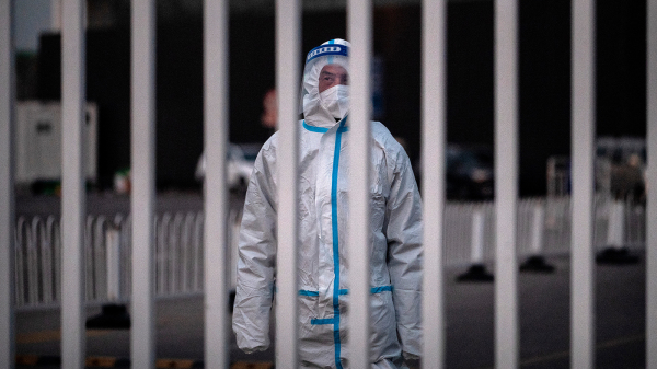 2022年12月7日，北京一名防疫人员守在一个检疫设施的门口。