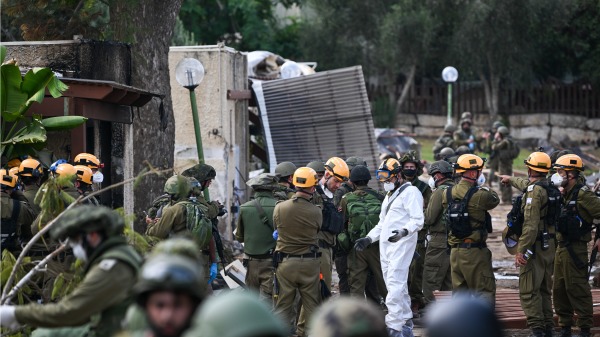 2023年10月10日，以色列國防軍成員正在清理房屋並整理幾天前在哈馬斯武裝分子在加沙邊境附近的基布茲發動的襲擊中喪生的平民屍體。（Alexi J. Rosenfeld/Getty Images)