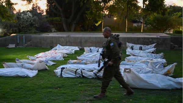 2023年10月11日，以色列贝埃里，靠近加萨边境，在贝埃里基布兹的主战场上，一名以色列国防军士兵走过装有20 多名哈马斯武装分子尸体的尸袋。