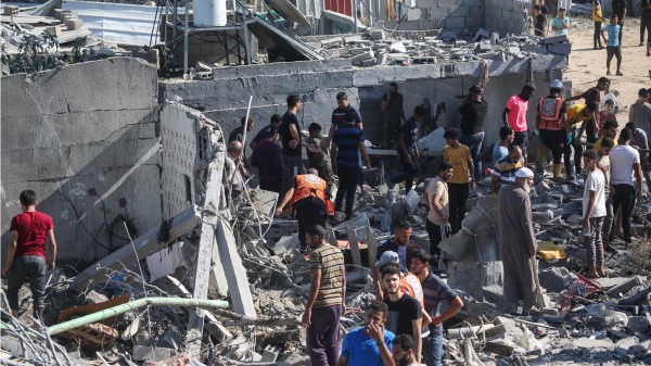 巴勒斯坦緊急服務部門和當地公民在 2023年10月19日加沙走廊南部汗尤尼斯以色列空襲中被摧毀的建築物中尋找罹難者。(Ahmad Hasaballah/Getty Images)(