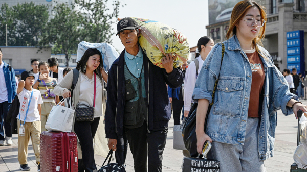 今年十一长假期间旅客们携带行李抵达北京站。（图片来源：Getty Images）