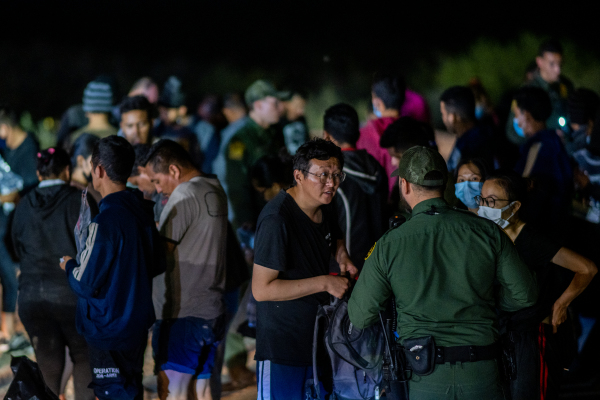 2022年5月5日，一名中国人在德州越过格兰德河进入美国后，在接受处理之前与边境巡逻人员交谈。