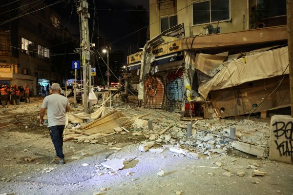 2023年10月7日，一名男子在特拉維夫一條佈滿廢墟的街道上行走，街道被巴勒斯坦武裝分子從加沙地帶發射的火箭彈擊中。