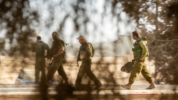 2023年11月13日，以色列国防军预备役人员在以色列南部步行穿越距离加沙边境不远的地区。