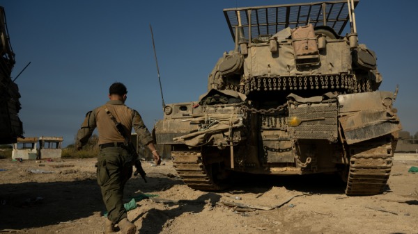 2023年11月17日，在以色列南部，一名以色列國防軍士兵在加沙北部邊境附近指揮坦克駕駛員。