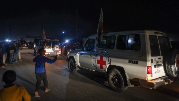 2023 年11 月24 日，國際紅十字會的車輛載著哈馬斯釋放的人質穿過加薩的拉法邊境點，前往埃及，他們將從那裡飛往以色列與家人團聚。(MOHAMMED ABED/AFP via Getty Images)