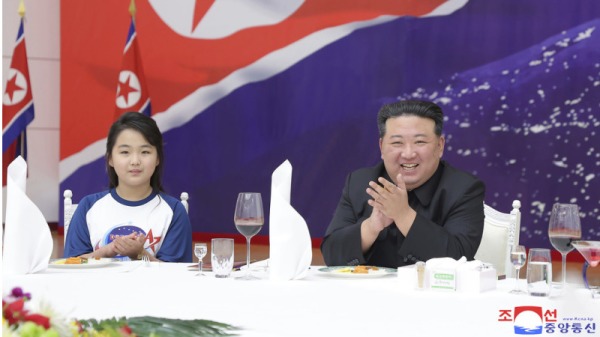 金正恩（右）和女儿金主爱（左）一起出席了侦察卫星发射成功庆功宴。