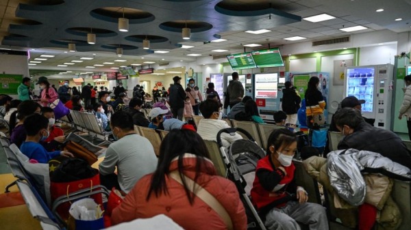 儿童和他们的父母在北京一家儿童医院的门诊区等候