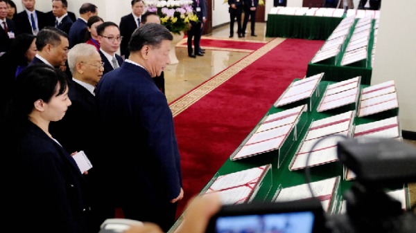 2023年12月12日，中国国家主席习近平和越南共产党总书记阮富仲（中左）走过河内越南共产党中央办公厅展示的签署协议。