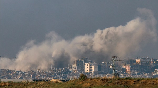 2023 年 12 月 13 日在以色列南部与加萨走廊边界附近拍摄的照片显示，以色列与激进组织哈马斯之间的战斗仍在继续，以色列轰炸加萨北部时浓烟滚滚。（MENAHEM KAHANA/AFP via Getty Images)(