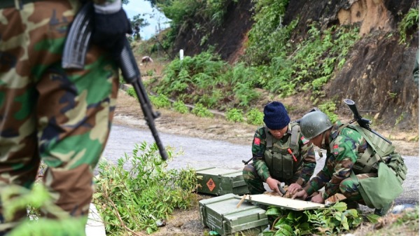 2023年12月13日示，在缅甸北部掸邦南山镇，少数民族武装组织德昂民族解放军 (TNLA) 的成员在与缅甸军方的冲突中准备武器。
