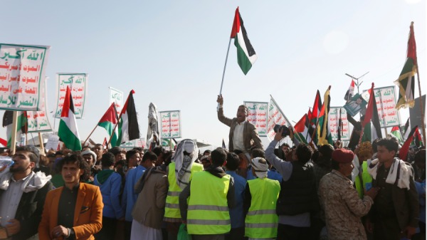 2023年12月22日，也门人举起印有胡塞运动领导人阿卜杜勒．马利克．巴德雷丁．胡塞的标语牌，以及巴勒斯坦和也门国旗，高呼口号，参加声援胡塞武装的抗议活动。