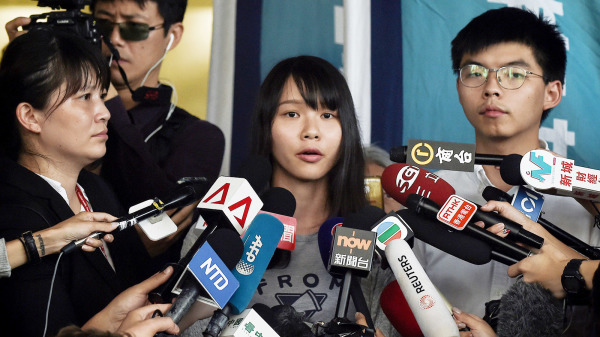 图为香港社运人士周庭（中），2019年8月30日和黄之锋（右一）见记者。（图片来源：Getty Images）