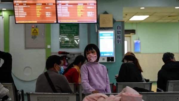 2023 年 11 月 23 日，兒童和他們的父母在北京一家兒童醫院的門診區等候。 