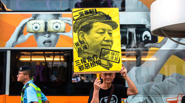 圖為2014年佔中運動期間，香港市民手舉反對習近平一黨專制的抗議海報。（圖片來源：Getty Images）