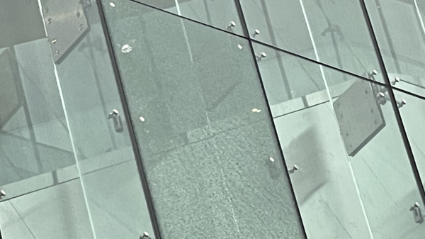 西九龙裁判法院大楼一幅玻璃幕墙，在2月8日47人案审讯期间，怀疑被人射击导致爆裂。（图片来源：VOA）