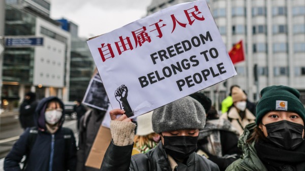 2022年12月3日，在德國柏林，一名示威者在中國大使館前舉行的抗議活動中舉着寫着「自由屬於人民」的橫幅，聲援中國的抗議者 。