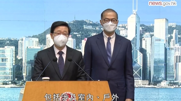 李家超与医务卫生局局长卢宠茂周二（28日）宣布香港3月1日起全面取消口罩令，室内外、公共交通均无须戴口罩。（政府新闻网）
