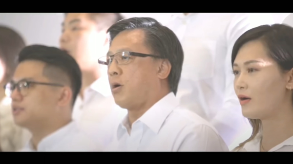 2019年立法會議員何君堯（中）聯同他人將《願榮光歸香港》，改成撐警的《願平安歸香港》，又拍攝MV親自領唱，全體歌唱人員以白衣示人。（圖片來源：視頻截圖）