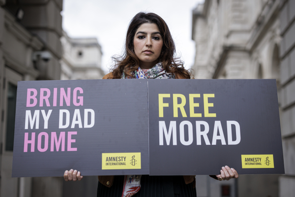 2022年4月13日，塔拉·塔赫巴兹在英国伦敦的外交、联邦和发展办公室外举着标语牌，要求英国政府营救父亲。