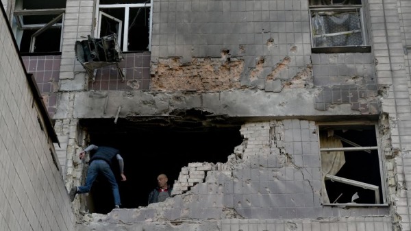 2023年5月28日，在主要针对乌克兰首都基辅的大规模俄罗斯无人机袭击后，当地居民检查了一座部分被毁的住宅楼。