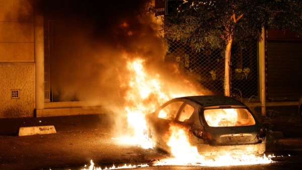 2023年6月28日巴黎西部楠泰爾抗議活動中一輛燃燒的汽車，一天前，楠泰爾一名 17 歲男孩因拒絕服從而被一名警察開槍打死