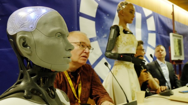 2023年7月7日在瑞士日內瓦舉行的新聞發布會上，英國製造商 Engineered Arts 首席執行官兼創始人 Will Jackson 旁邊的人形機器人 Ameca（左）向媒體發表講話。 