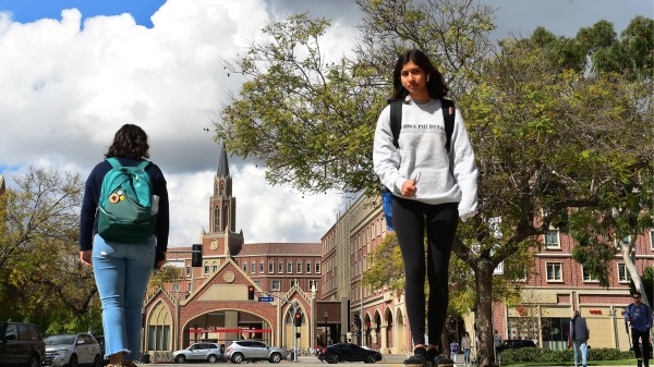2020 年 3 月 11 日，學生們走在位於美國加州洛杉磯的南加州大學 (USC) 校園內（FREDERIC J. BROWN/AFP via Getty Images）