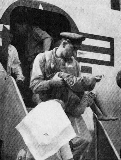 圖為1954年國泰空難後，前來救援的美國SA-16機長將六歲的乘客抱下飛機。（圖片來源：公有領域）