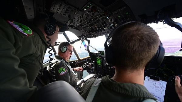 2021年9月17日，迈克尔·米尼汉中将（中）驾驶一架 C-130J 超级大力士飞越阿肯色州中部上空。