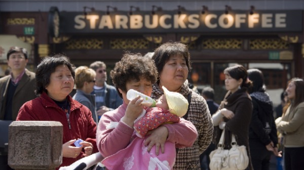 一名妇女在上海豫园集市的星巴克外给婴儿喂奶，中国曾经实行的独生子女政策令减少人口。