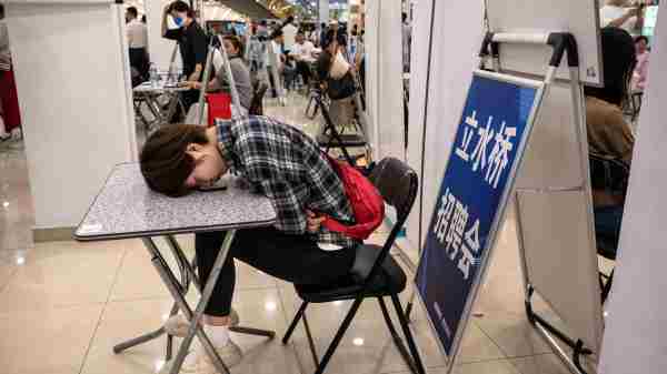 2023年6月9日，在中國北京舉行的一場招聘會上，一位求職者趴在一張桌子上。