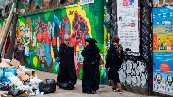 2017年7月23日，三名戴著頭巾的婦女走過倫敦東區「紅磚巷」（Brick Lane）附近的塗鴉。