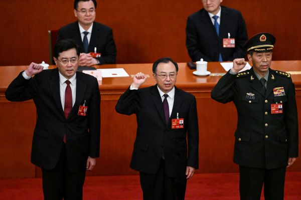 2023年3月12日，新被提拔的国务委员秦刚、吴正龙（中）、李尚富在中共全国人大五次会议上宣誓。