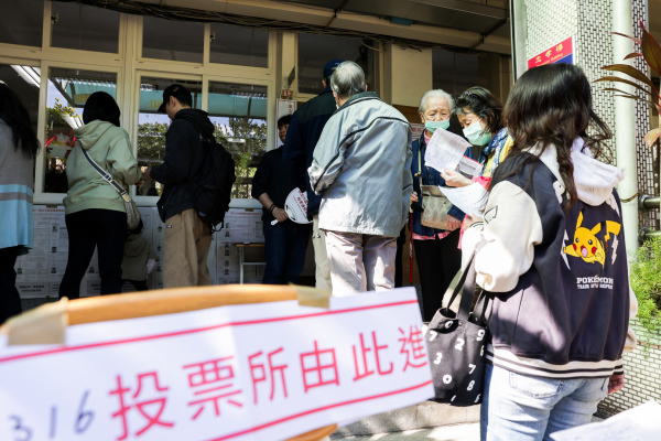 2024年1月13日，臺灣總統大選投票期間，人們在臺北的一個投票站排隊等待投票。