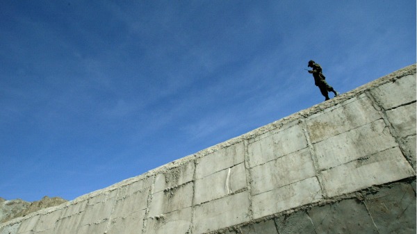 在伊朗和巴基斯坦邊界交界處，一名伊朗士兵在圍牆上站崗。