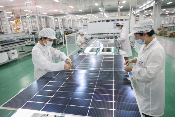 2024年1月4日，江蘇省連雲港市一家工廠的員工正在生產即將出口的太陽能光伏組件。