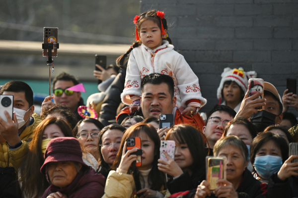 2024年2月12日，北京龙年大年初三，人们在东岳庙会上观看舞龙表演。