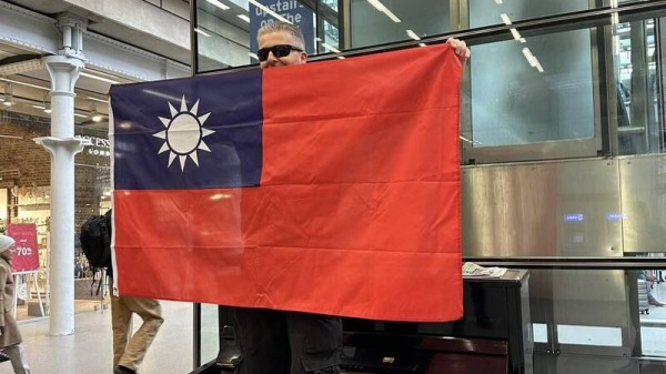 英國鋼琴家手舉台灣國旗。（圖片來源：臉書截圖）