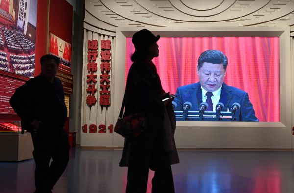 2024年2月29日，北京中國共產黨博物館內，遊客走過顯示習近平的屏幕前。