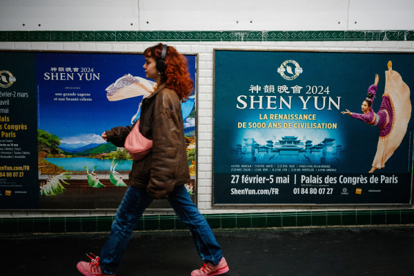 2024年3月1日，一名女子走過巴黎地鐵站的神韻海報。