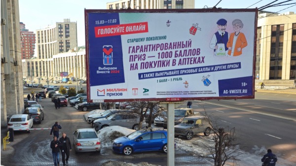 2024年3月14日，俄罗斯莫斯科，人们走过一块宣布即将举行俄罗斯总统选举的广告牌，并提出在线投票以赢得奖品。