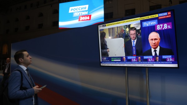 2024年3月18日早些时候，俄罗斯莫斯科，一名男子在俄罗斯总统弗拉基米尔．普京竞选总部的电视监视器上观看。 