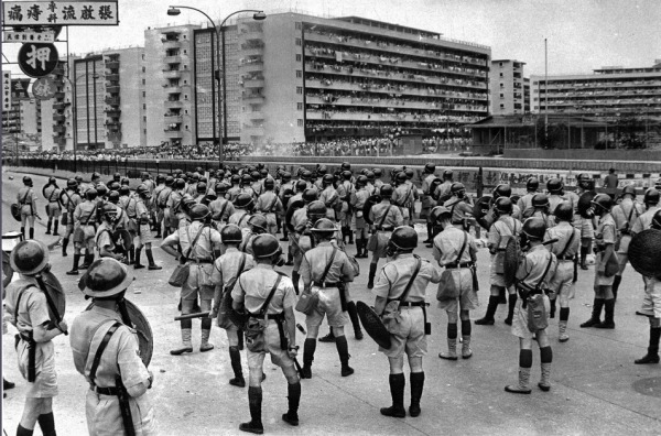 1967年5月12日，骚乱扩展至东头邨，隔着大水渠对峙。陈桥离开警队范围拍摄遇险。