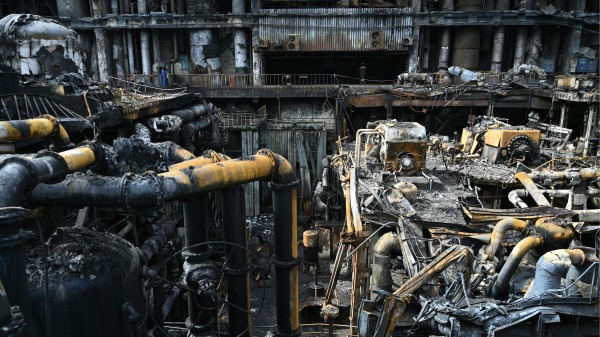 工人在乌克兰一处秘密地点清理能源供应公司DTEK发电厂内涡轮机的碎片，该发电厂在俄罗斯军队一次袭击中被毁。