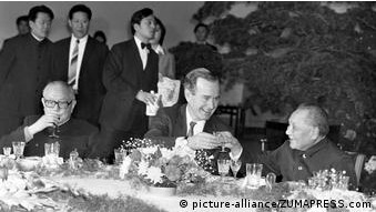 1989年2月，老布希（中）在北京和鄧小平（右）