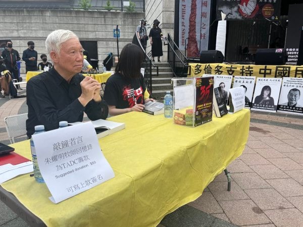 占中三子之一朱耀明牧师在六四纪念晚会现场签名售书，款项捐给多伦多民运会。（看中国摄）