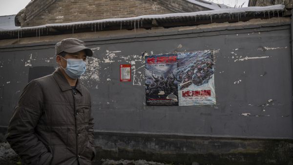 2021年11月7日，中国北京，一名男子走过电影《长津湖》的海报。