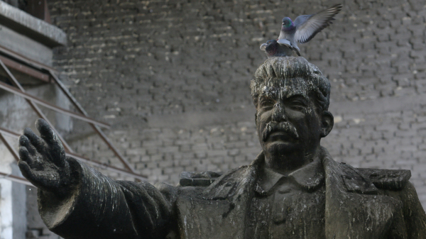 2013年4月15日，在阿尔巴尼亚的首都地拉那，两只鸽子站在铸造厂仓库中的前苏联独裁者斯大林的雕像上。这些共产主义时代雕像的青铜将被用来铸造新的艺术品。
