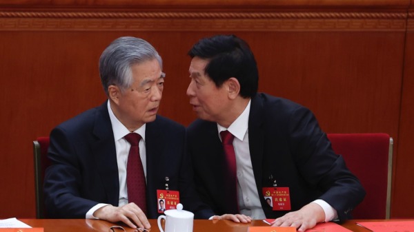  2022年10月22日，中共中央政治局常委栗战书（右）在中共二十大闭幕式上与中国前国家主席胡锦涛（左）交谈。（图片来源：Lintao Zhang/Getty Images）